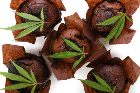 Chocolate cannabis muffins with leaves on white background, closeupの写真素材