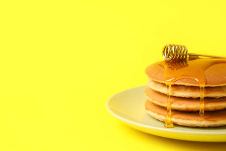 Plate of tasty pancakes with honey on color background, closeupの写真素材