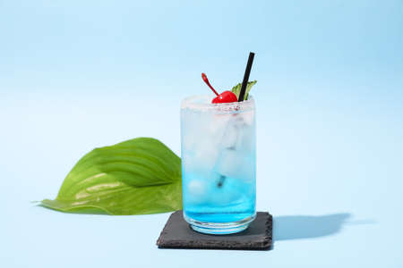 Glass of Blue Lagoon cocktail on color backgroundの写真素材