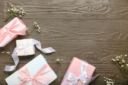 Beautiful spring composition with flowers and gift boxes on wooden background
