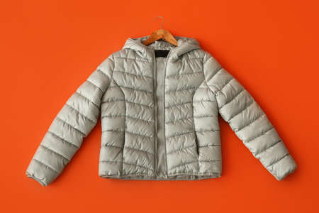 Stylish down jacket on red background