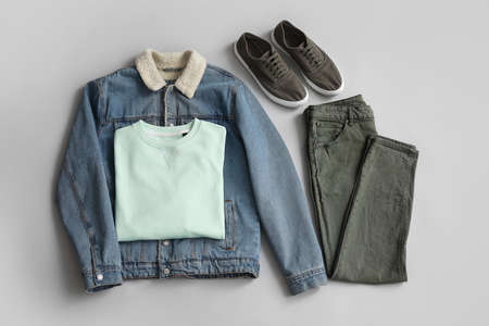 Stylish male clothes with sneakers on gray background