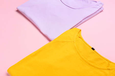 Stylish t-shirts on pink background, closeup