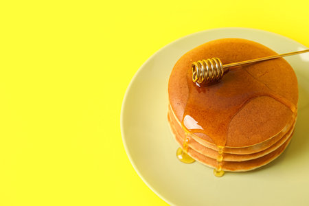 Plate of tasty pancakes with honey on color backgroundの写真素材