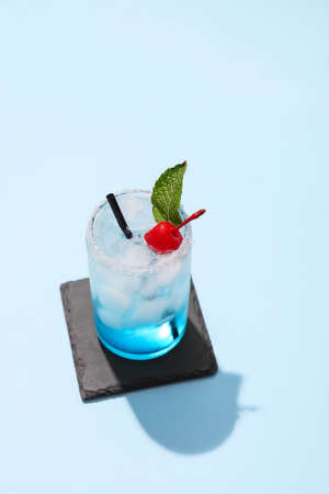 Glass of Blue Lagoon cocktail on color backgroundの写真素材
