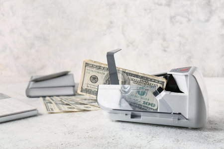 Dollars in currency counting machine on light backgroundの写真素材