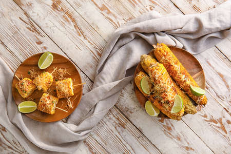 Plates with delicious Elote Mexican Street Corn on white wooden backgroundの写真素材