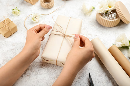Woman packing gift box on grunge background, closeupの写真素材