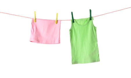 Child clothes hanging on rope with clothespins against white background