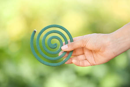 Woman with mosquito spiral outdoors, closeupの写真素材