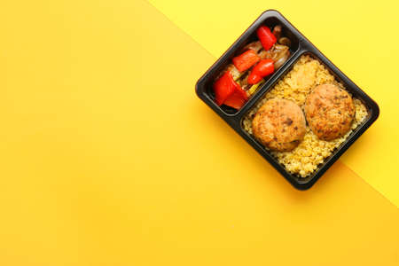 Container with delicious lunch on color backgroundの写真素材