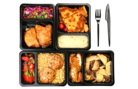 Lunch boxes with food and cutlery on white background