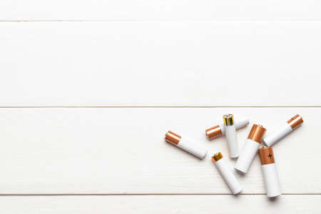 Alkaline batteries on white wooden backgroundの写真素材