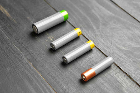 Alkaline batteries on black wooden backgroundの写真素材
