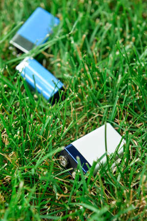 Alkaline batteries on green grass outdoorsの写真素材