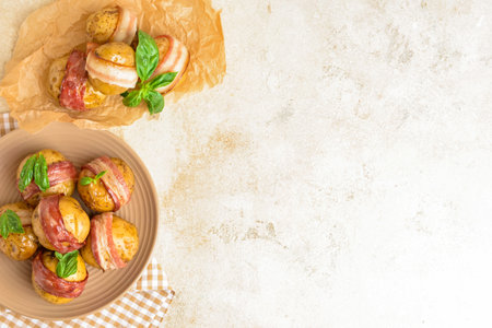 Plate of delicious baked potatoes with bacon on light backgroundの写真素材
