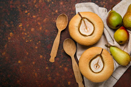 Tasty pear pot pies and fresh fruits on grunge background
