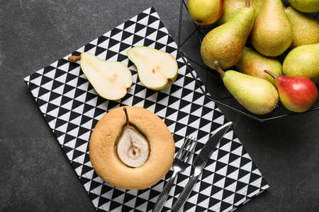 Tasty pear pot pie and fresh fruits on dark background