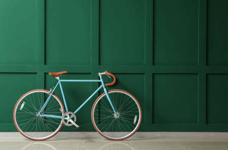Stylish bicycle near green wall
