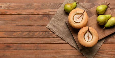 Board with tasty pear pot pies and fresh fruits on wooden backgroundの写真素材