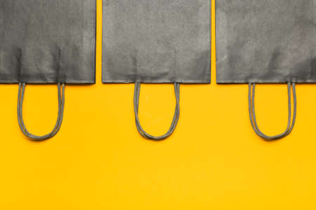 Shopping bags on color background