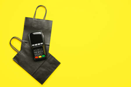 Shopping bags and payment terminal on color background. black friday saleの写真素材