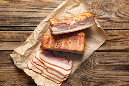 Tasty smoked bacon on wooden backgroundの写真素材