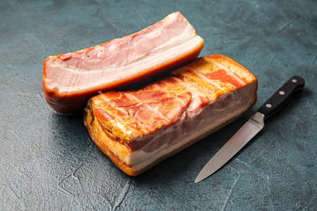 Tasty smoked bacon on dark background