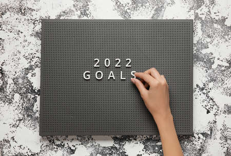 Female hand with text 2022 GOALS on board against grunge backgroundの写真素材