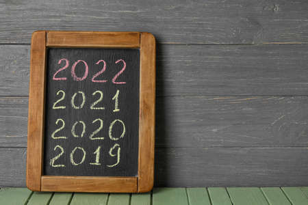 Figures denoting years 2019-2022 on chalkboard against wooden backgroundの写真素材