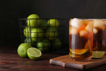 Board with glasses of tasty Long Island iced tea on table, closeup