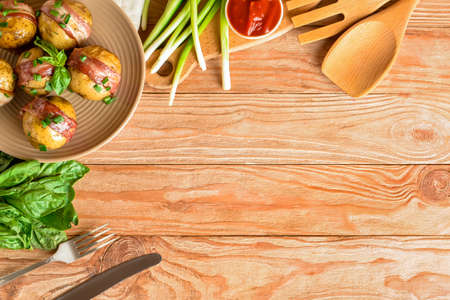 Plate of tasty baked potatoes with bacon and green onion on wooden background, closeupの写真素材