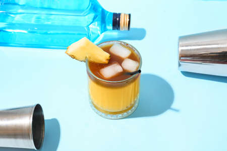 Glass with delicious mai tai cocktail on color and measure cup on color table