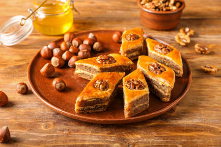 Plate with tasty baklava on wooden background