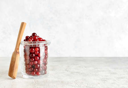Jar with healthy cranberries on light backgroundの写真素材