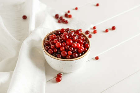 Bowl with healthy cranberry on light wooden backgroundの写真素材