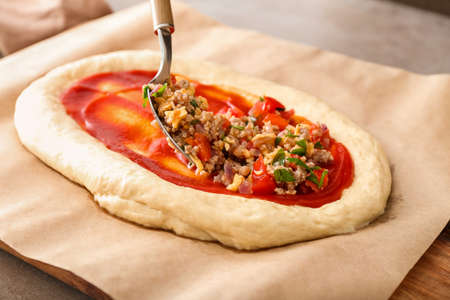 Preparing of Turkish Pizza on gray backgroundの写真素材