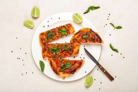 Plate with sliced Turkish Pizza on white backgroundの写真素材