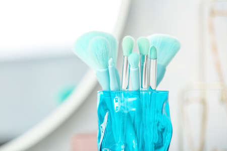 Glass with set of makeup brushes, closeup