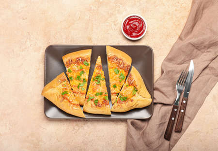 Plate with sliced Turkish Pizza on beige background