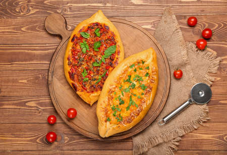 Board with delicious Turkish Pide Pizza on wooden backgroundの写真素材