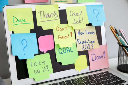 Modern laptop with sticky notes on table, closeup