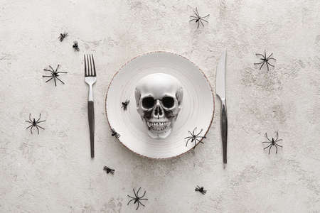 Halloween table setting with skull on light backgroundの写真素材