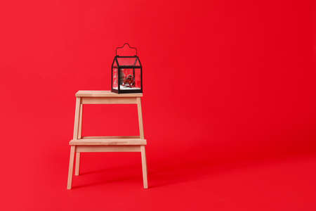 Wooden step stool with Christmas gift on red backgroundの写真素材