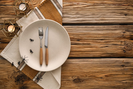 Halloween table setting with spiders and candles on wooden backgroundの写真素材