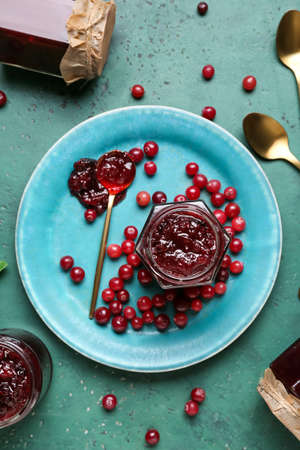 Composition with tasty cranberry jam and fresh berries on green backgroundの写真素材