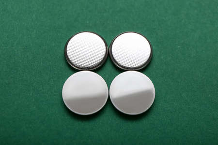 Lithium button cell batteries on green background
