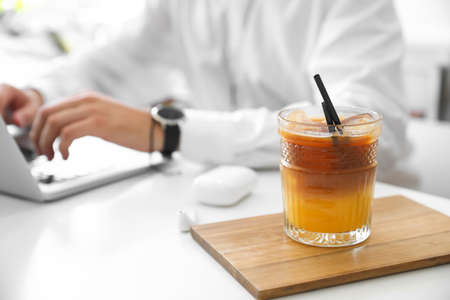 Glass of cocktail with ice on table in cafe, closeupの写真素材
