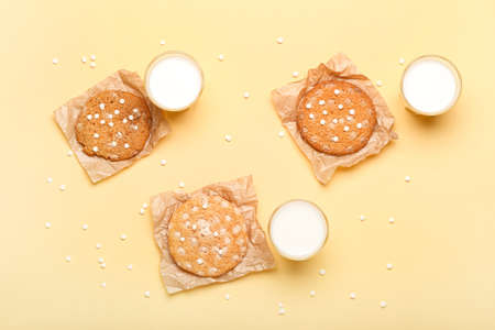 Parchments with delicious chocolate cookies and glasses of milk on color backgroundの写真素材