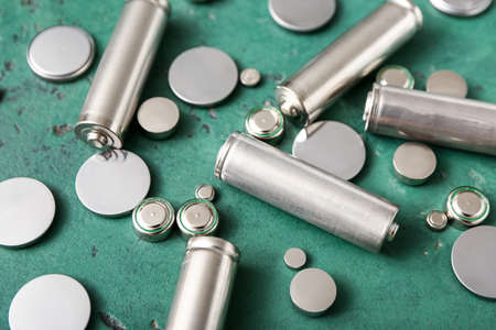 Different batteries on green background, closeup